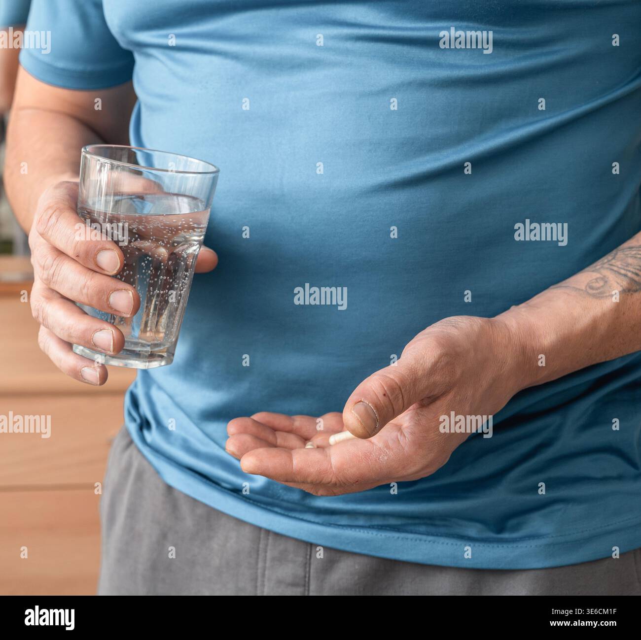 Homme prenant un supplément oral ou un médicament prescrit. Concept de santé, de bien-être, de traitement et de routine quotidienne Banque D'Images