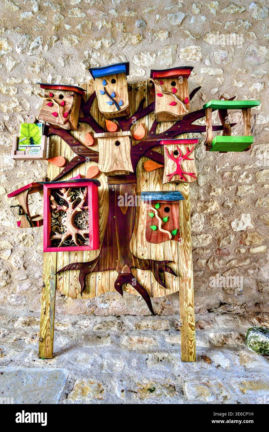 Exposition de nichoirs colorés faits à la main pour oiseaux sur une planche de fond ressemblant à un arbre - angles-sur-l'Anglin, Vienne (86), France. Banque D'Images