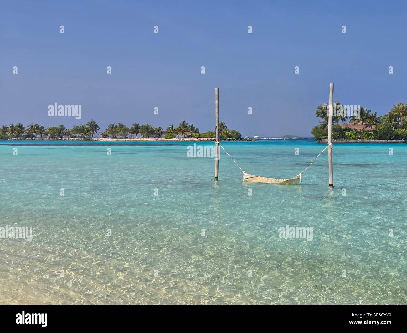 Destination tropicale montre des eaux calmes et des plages de sable blanc ainsi que des villas sur l'eau aux Maldives par une journée ensoleillée. Banque D'Images