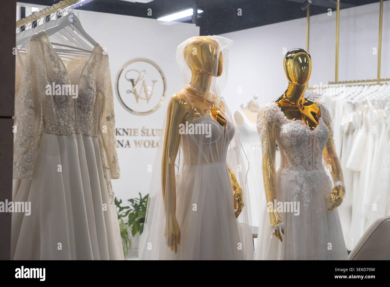 Cracovie, Pologne - 2 décembre 2025 : vitrine captivante présentant de délicates robes de mariée blanches sur d'élégants mannequins dorés, mettant l'accent sur la mariée Banque D'Images