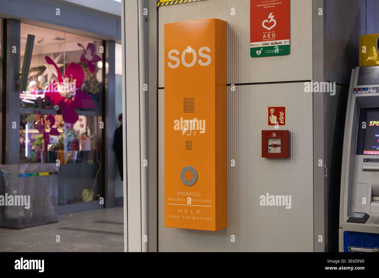 Cracovie, Pologne - 1er décembre 2025 : gros plan d'une boîte d'appel d'urgence orange SOS affichant le texte DE L'AIDE EN APPUYANT SUR LE BOUTON, mettant l'accent sur l'accès instantané à sa Banque D'Images