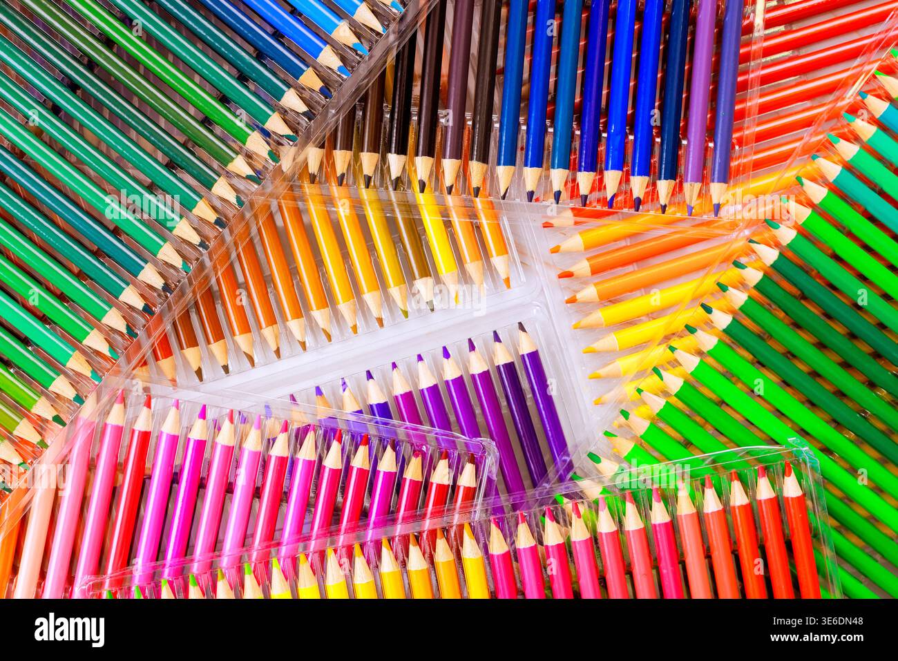 Des crayons de couleur de différentes couleurs sont placés dans des rangées soignées sur une surface légère prête pour des projets d'art. Banque D'Images