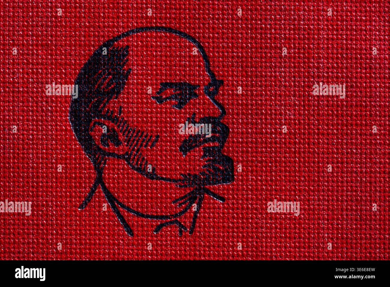 Profil graphique noir de vladimir lénine imprimé sur une surface texturée rouge, rétro, gros plan. Représentant de l'histoire soviétique, du communisme et de l'URSS ideo Banque D'Images