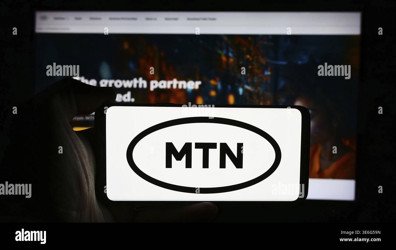 Stuttgart, Allemagne - 08-21-2024 : personne tenant un téléphone portable avec le logo de la société sud-africaine de télécommunications MTN Group Limited en face de la page web. Banque D'Images