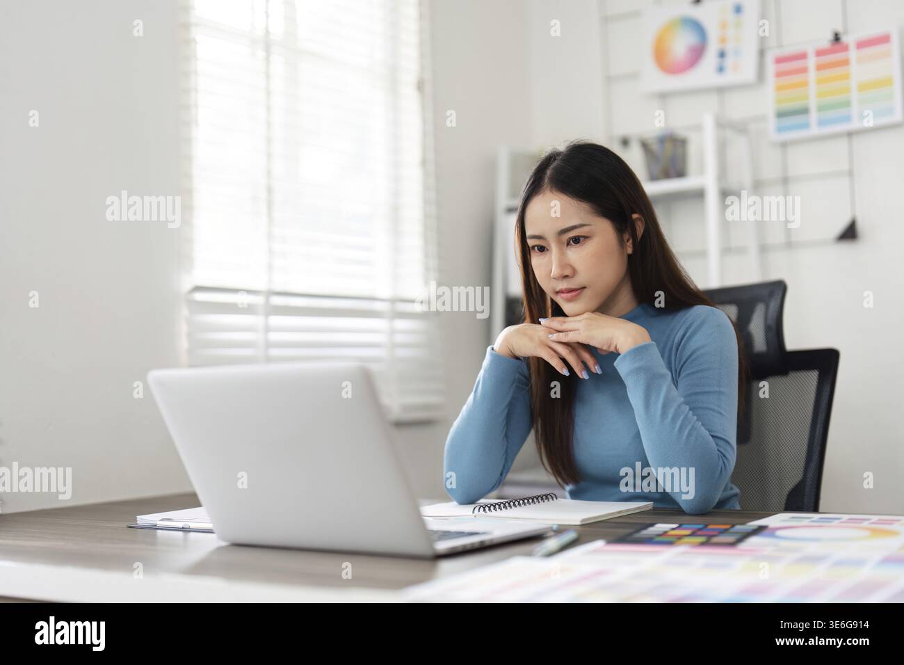 Une jeune femme réfléchie s’engage dans son travail de design, apportant vision artistique et dévouement à son processus numérique et créatif Banque D'Images