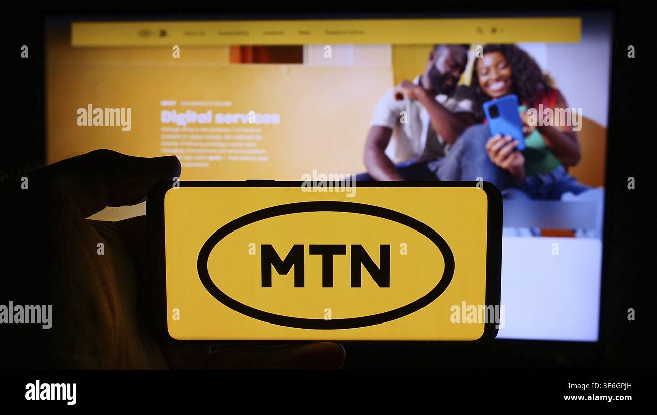 Stuttgart, Allemagne - 08-07-2024 : personne tenant un téléphone portable avec le logo de la société sud-africaine de télécommunications MTN Group Limited en face de la page web. Banque D'Images