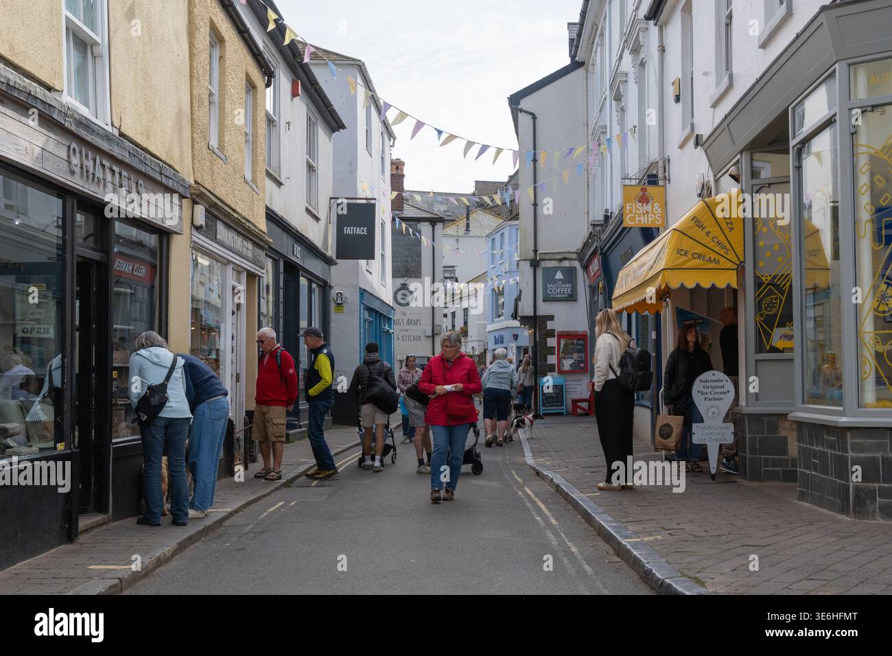 Fore Street, High Street de Salcombe, en automne avec des gens de shopping de fenêtre et se promener le long en passant l'heure de la journée, banderole et auvent lumineux. Banque D'Images