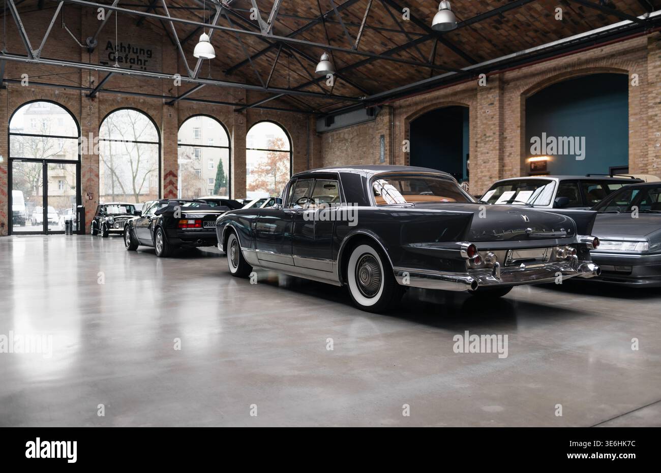 Vue arrière de trois quarts de Facel Vega Excellence dans Classic remise. Rare berline des années 1950 garée parmi d'autres vieux véhicules dans un hall de style industriel. Banque D'Images