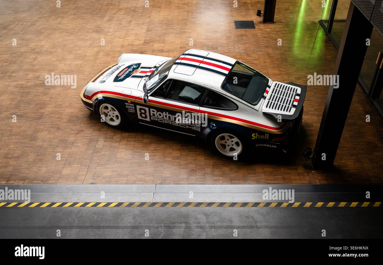 Porsche 911 classique dans la livrée de course Rothmans. Vue latérale à angle élevé d'une Porsche 911 des années 1970 avec aileron de queue de baleine sur un plancher en bois. Banque D'Images