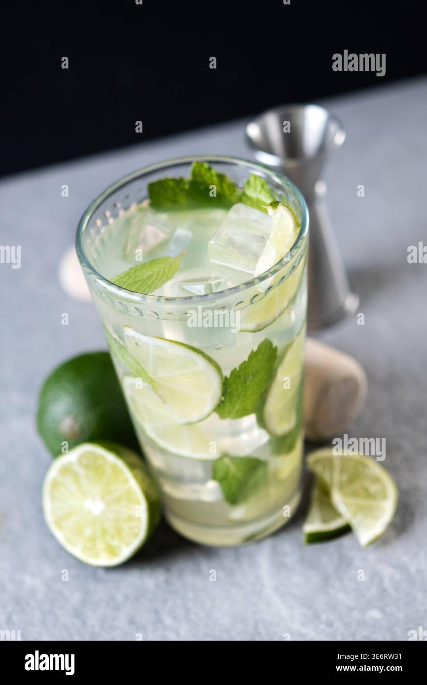 Cocktail de mojito frais avec citron vert, menthe et glace dans le verre sur fond sombre Banque D'Images