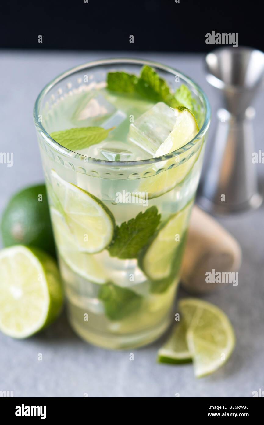 Cocktail de mojito frais avec citron vert, menthe et glace dans le verre sur fond sombre Banque D'Images