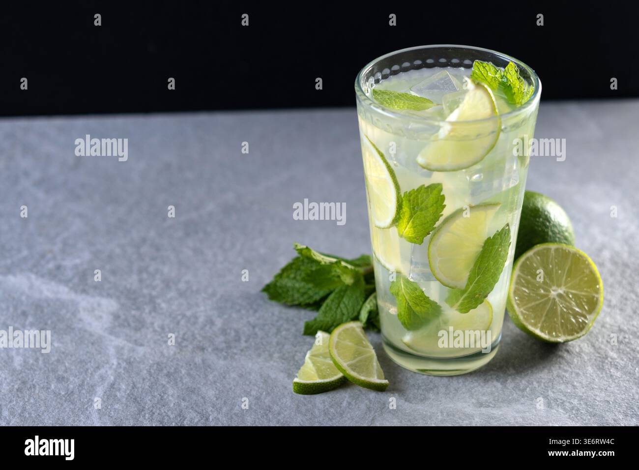 Cocktail de mojito frais avec citron vert, menthe et glace dans le verre sur fond sombre Banque D'Images