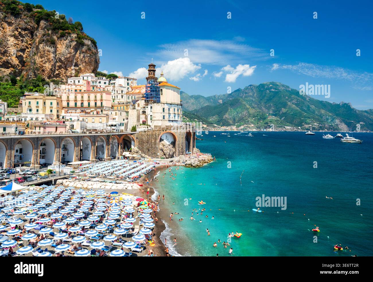 Vue sur le littoral de la ville d'Atrani nichée par la mer, avec des parasols et des gens se relaxant en été, en Europe Banque D'Images