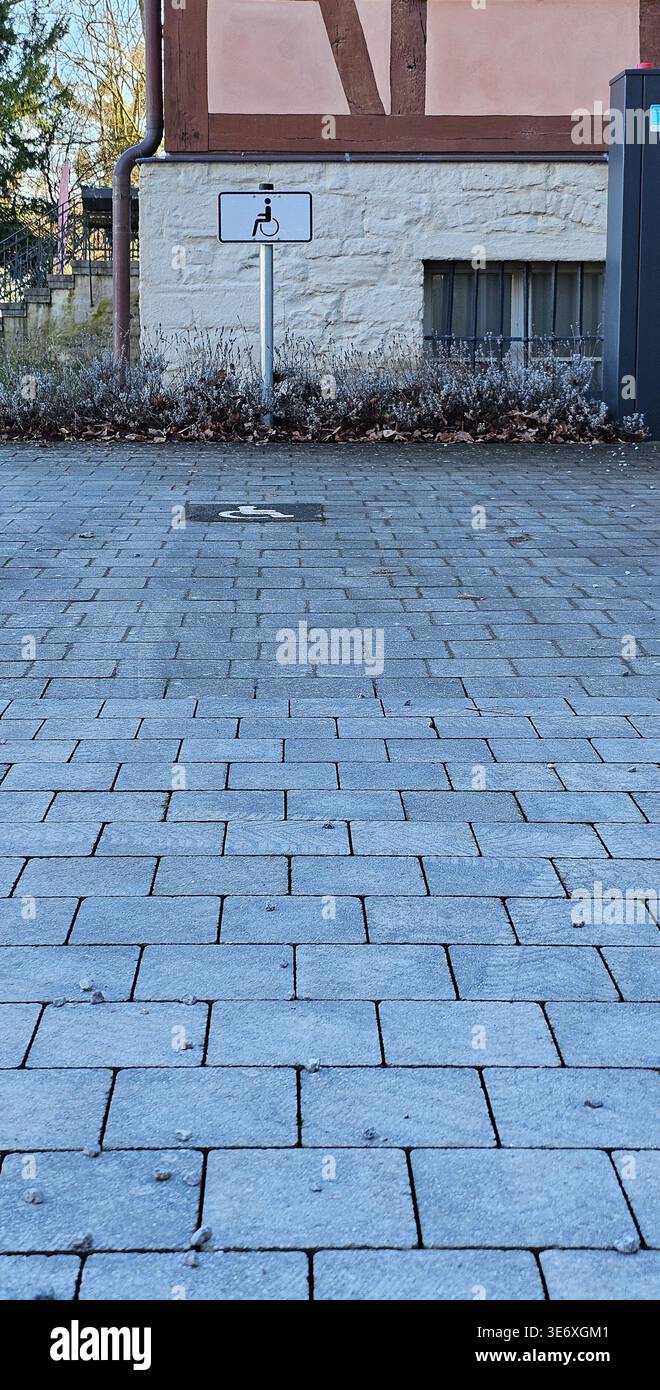 Le chemin pavé gris s'étend vers un bâtiment en briques et en pierre Banque D'Images