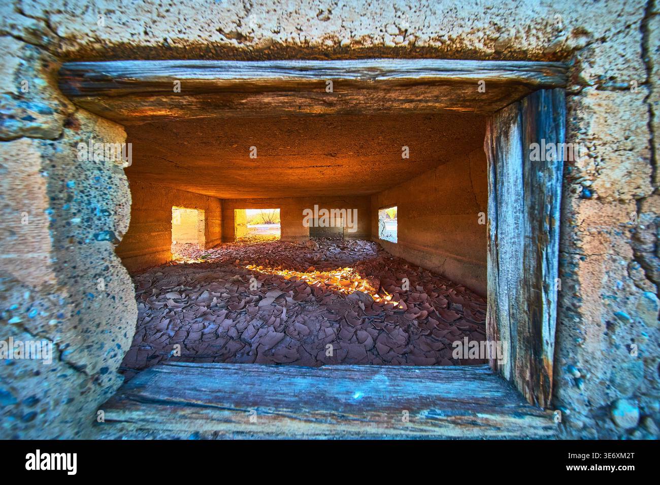 Intérieur abandonné du bâtiment de la ville fantôme avec lumière du soleil et sol en plâtre fissuré Banque D'Images
