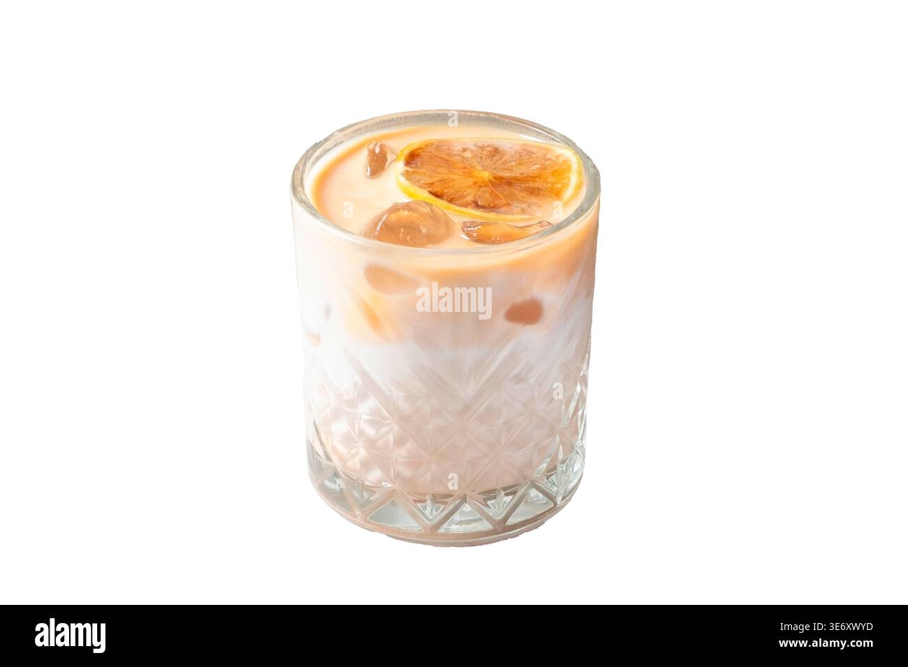 Latte glacé crémeux avec tranche d'agrumes séchés et glaçons dans le verre de roches de cristal isolé sur fond blanc Banque D'Images