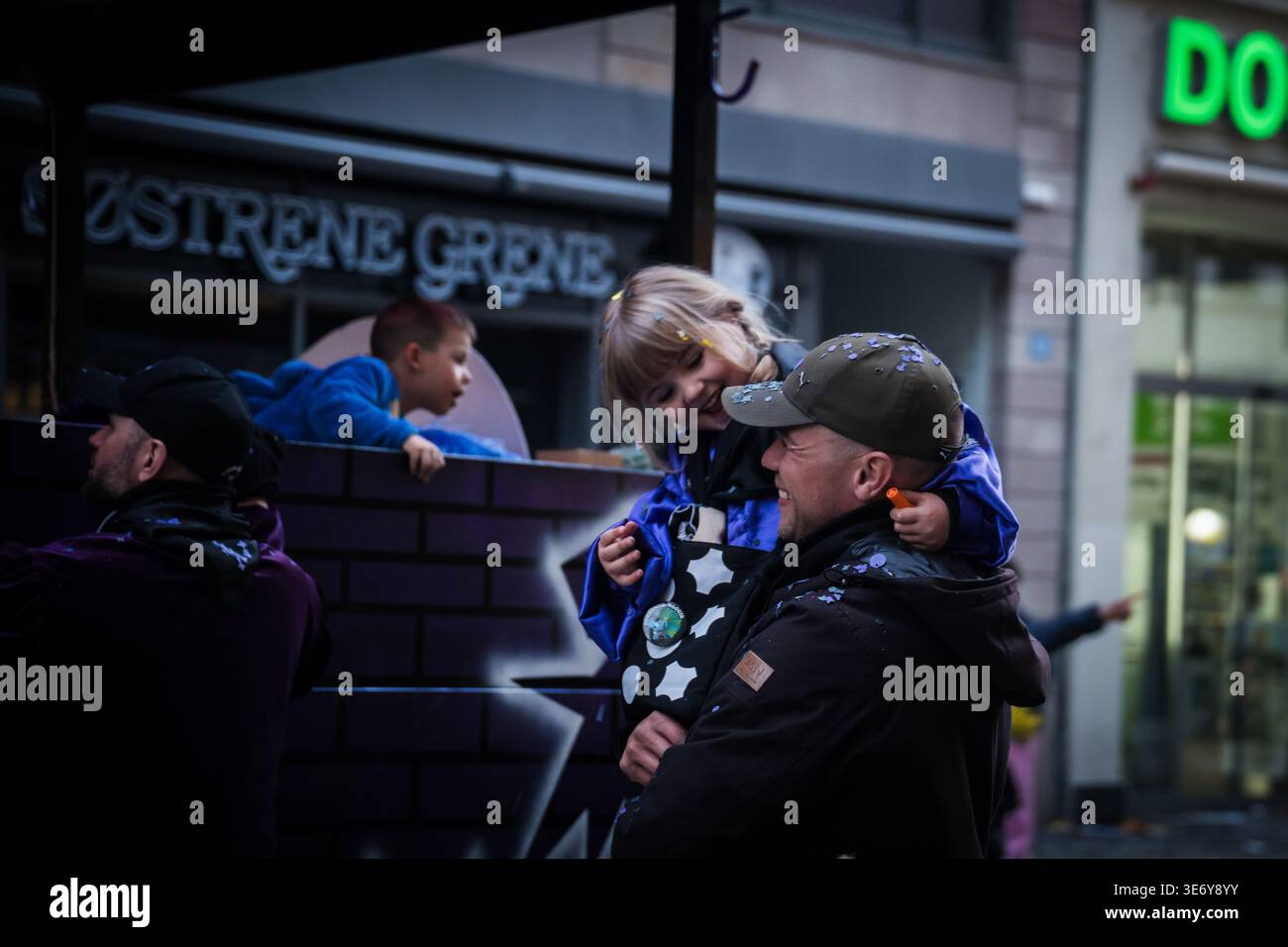Bâle, Suisse - 10 mars 2025 : vue d'un moment tendre au milieu des célébrations de Fasnacht, un enfant avec des confettis souriant d'une strass décorée Banque D'Images