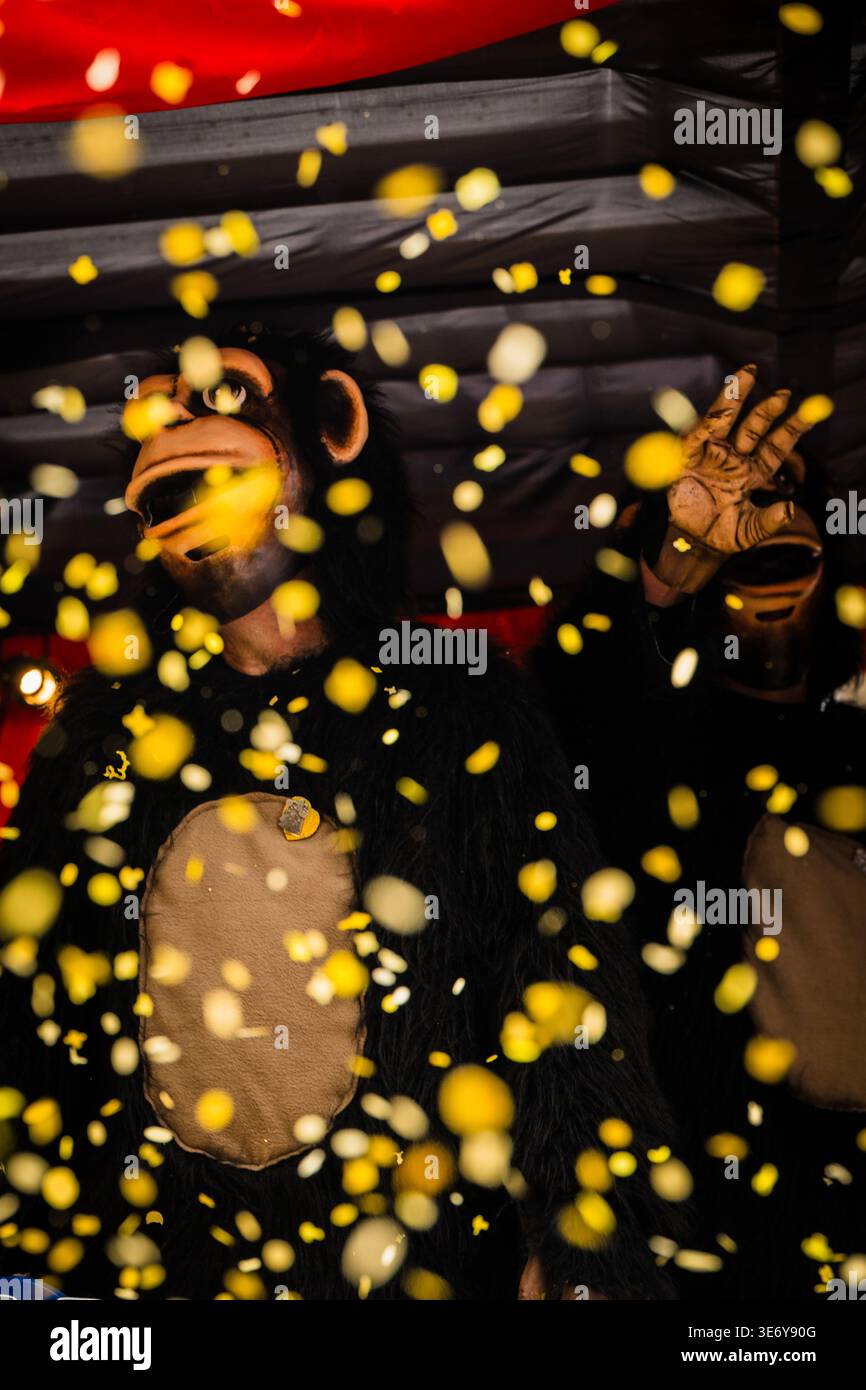 Bâle, Suisse - 10 mars 2025 : vue d'un fêteur costumé au milieu d'une vague de confettis, incarnant le chaos vibrant de Fasnacht. Banque D'Images