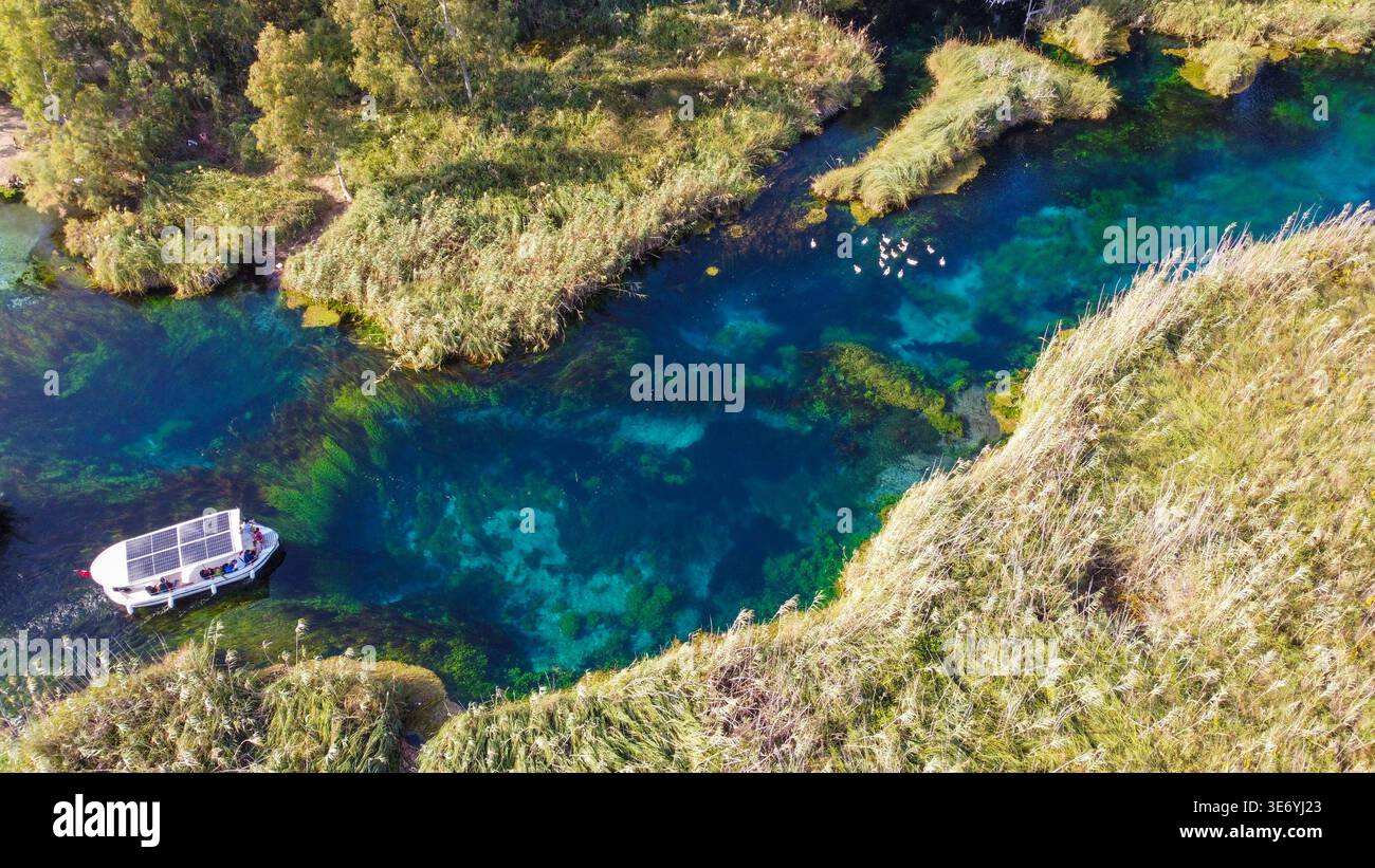 Vue aérienne de haut en bas de la rivière Crystal Clear Azmak avec bateaux d'excursion et roseaux à Akyaka Turquie Banque D'Images