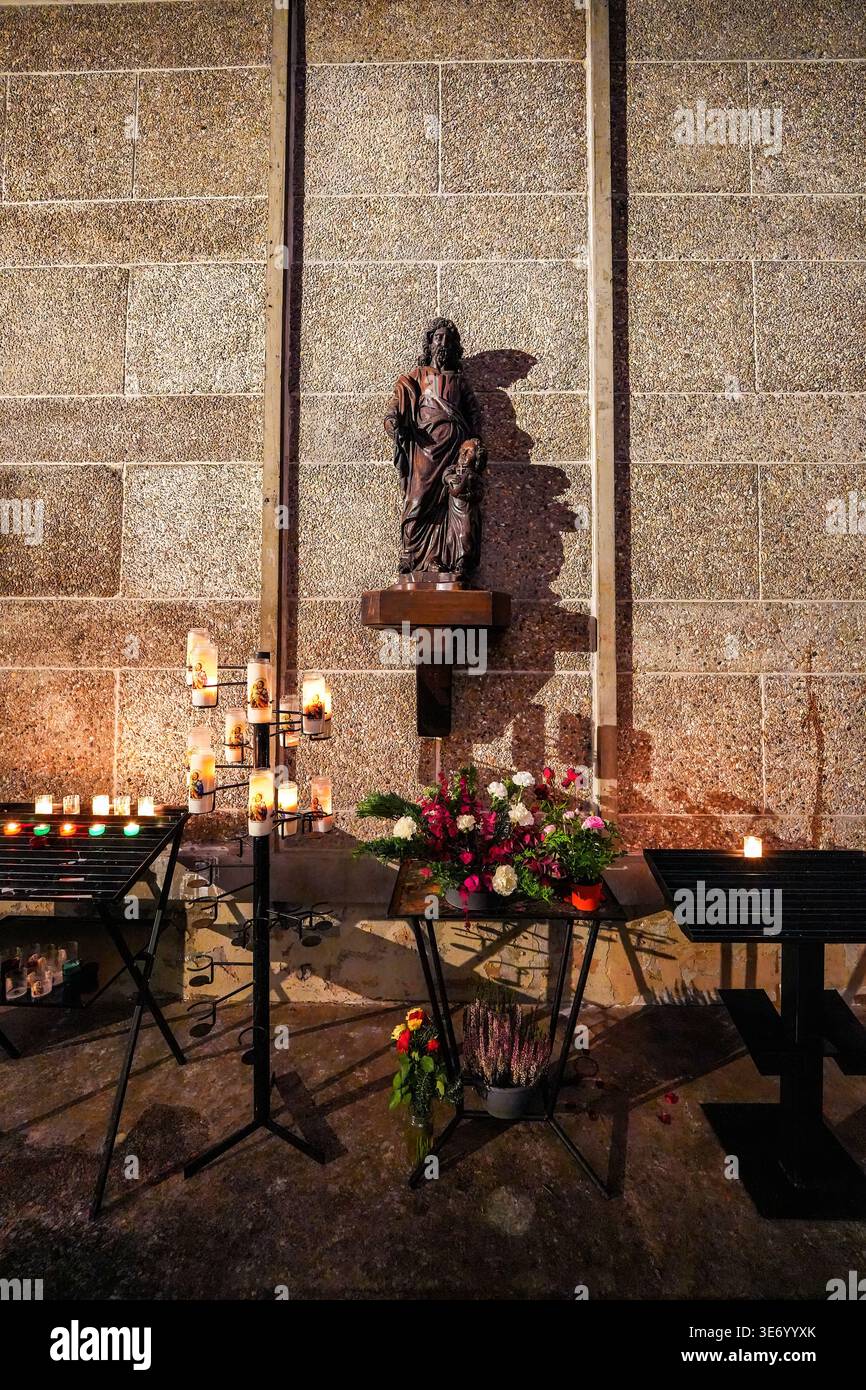 Bougies votives et statue de Saint Joseph dans une niche en béton dans l'église Joseph par Auguste Perret au Havre, Normandie, France Banque D'Images