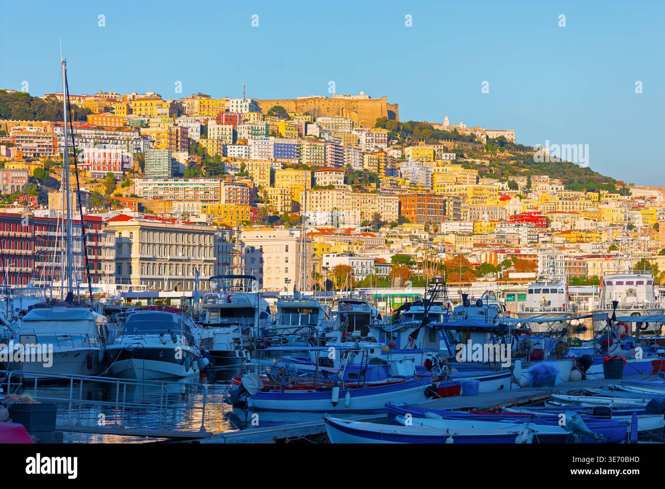 Port et colline colorée de Naples, Italie. Quartier Vomero surplombant un port de plaisance rempli de bateaux le long de la côte méditerranéenne Banque D'Images