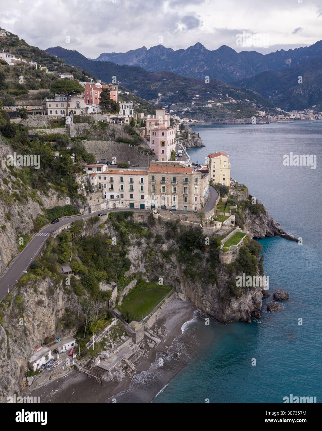 Vue aérienne de la ville d'Atrani et des bâtiments perchés le long de la côte amalfitaine, où les falaises escarpées rencontrent la mer turquoise, Atrani, Italie. Banque D'Images