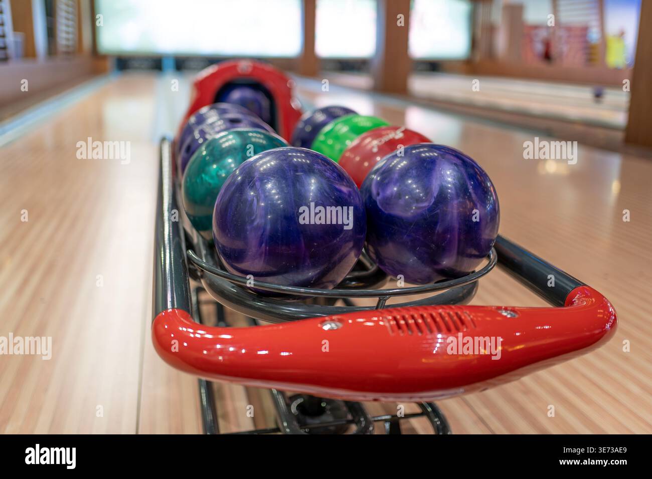 Boules de bowling sur le support de retour dans la piste de bowling prête pour le jeu et le divertissement de loisirs. Banque D'Images