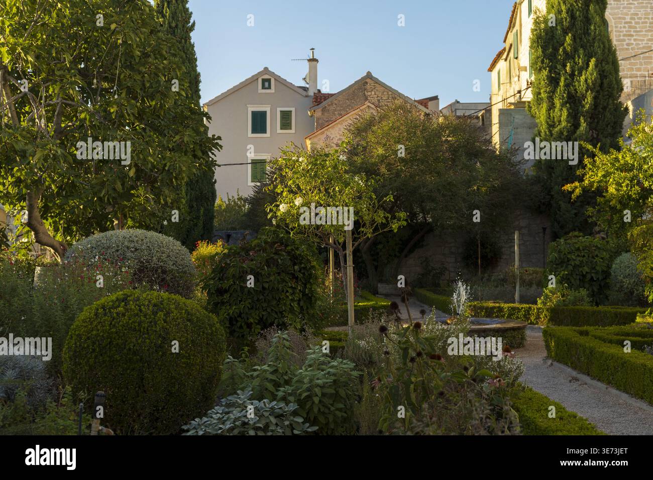 Beau chemin de jardin menant à la maison entourée de verdure luxuriante et de fleurs. Paysage extérieur paisible Banque D'Images