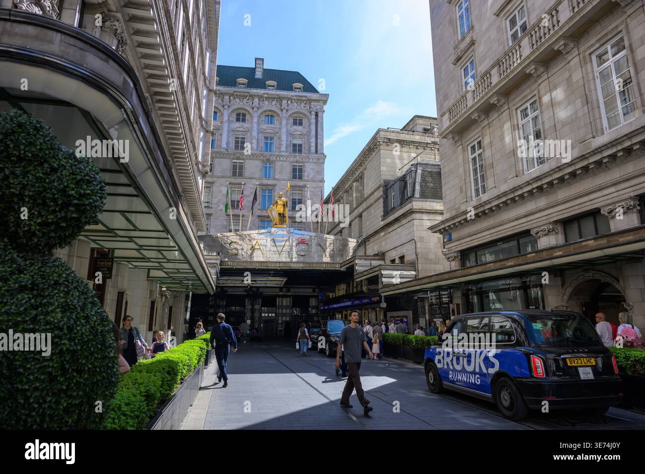 Vue sur Savoy court en direction du Savoy Hotel on the Strand à Londres, doté d'une architecture classique et d'une entrée d'hôtel de luxe emblématique. Banque D'Images