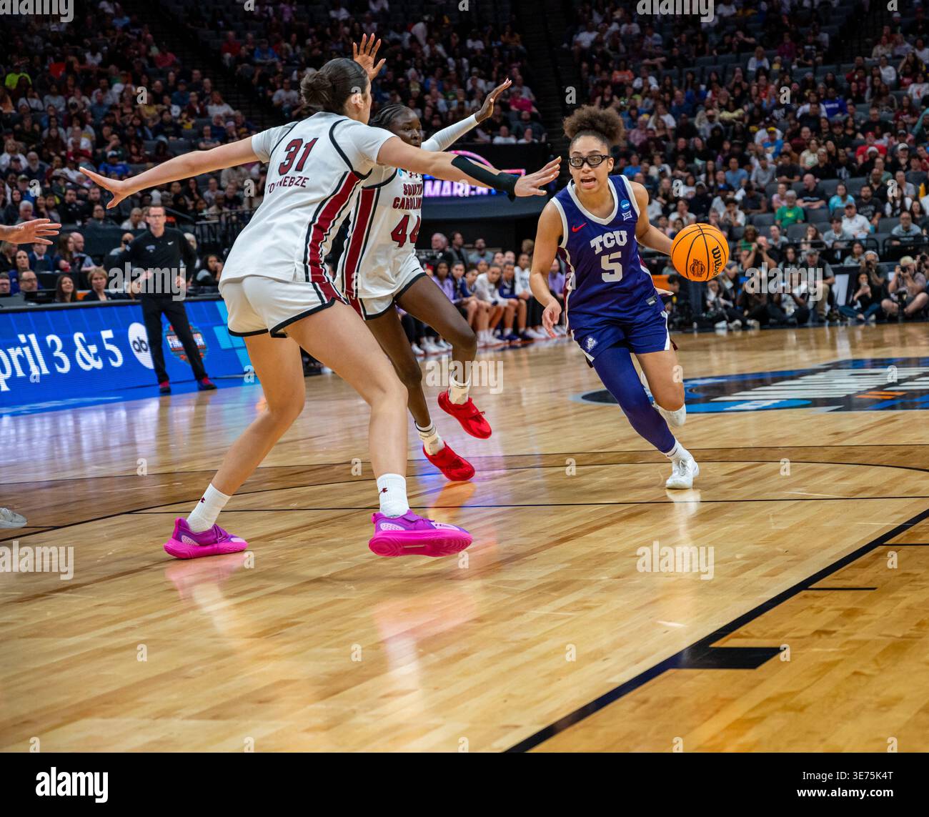 La garde de la TCU Olivia Miles (5) se dirige vers le panier contre la Caroline du Sud Sania Feagin (31) et Agot Makeer (44) lors de l'élite de basket-ball féminin de la NCAA Banque D'Images