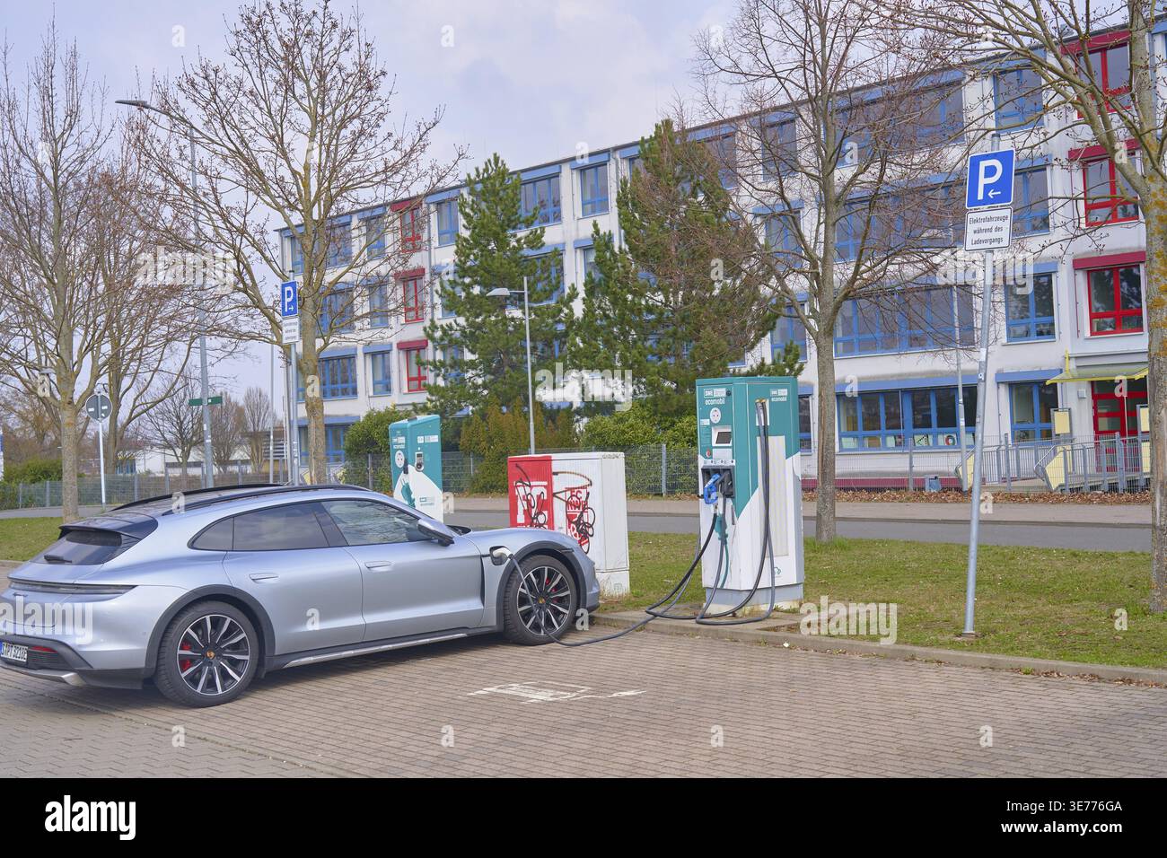 Métaphore de l'enseignement, aller à l'école et la mobilité électrique, recharge de voiture électrique à Ecomobil SWE Strom Stadtwerke Erfurt devant le scho professionnel Banque D'Images