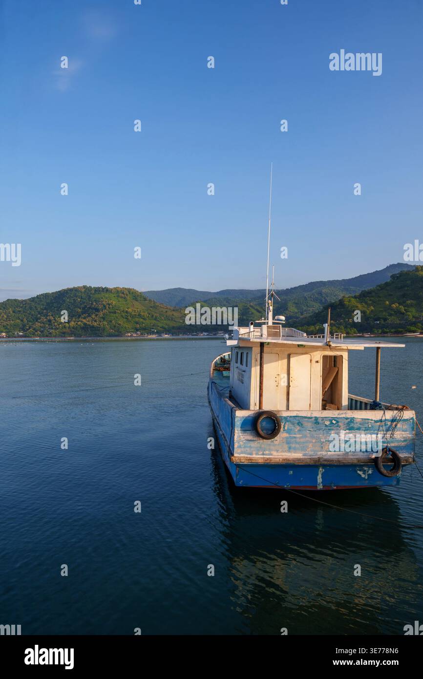 Un bateau de transport traditionnel en bois ancré dans la baie de Waworada avec un paysage montagneux pittoresque, Bima, West Nusa Tenggara, Indonésie. Banque D'Images