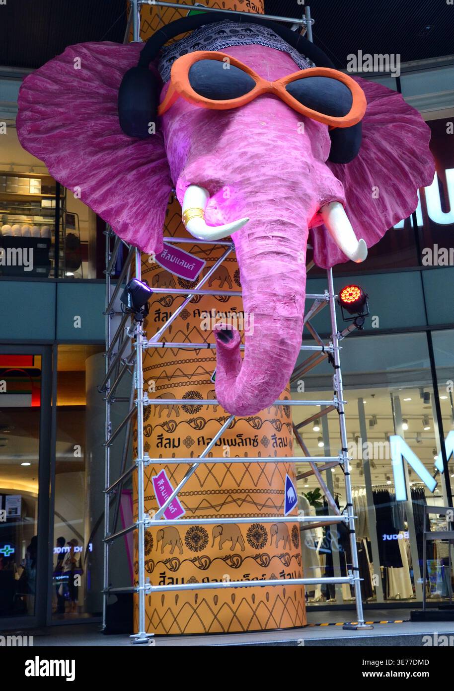 Une grande image d'éléphant de dessin animé annonçant le festival de l'eau de Songkran "Sawasdee Silom Land" devant le centre commercial Silom Complex dans le quartier Silom de Bangkok, en Thaïlande. Le festival de l'eau a lieu du 12 au 15 avril 2026, et mettra en vedette des foules trempant les uns les autres avec des pistolets à eau. Ce qui a commencé par verser doucement de l'eau sur les images de Bouddha et les aînés pour les bénédictions a évolué en célébrations nationales animées de jet d'eau. Le symbolisme est qu’il représente la purification – laver la malchance de l’année précédente et accueillir la nouvelle année avec de la chance. Banque D'Images
