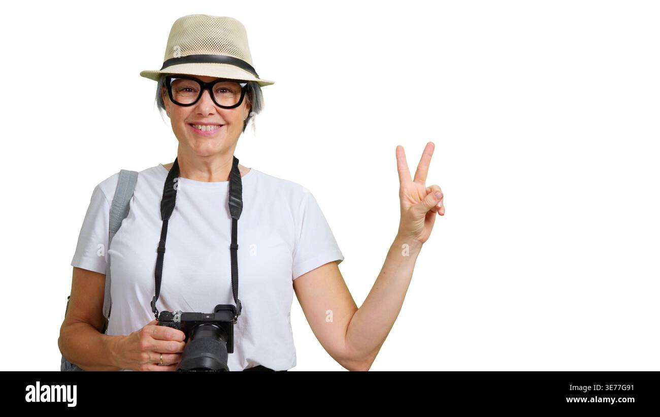 Heureuse femme senior touriste tenant la caméra faisant signe de paix ou de victoire Banque D'Images