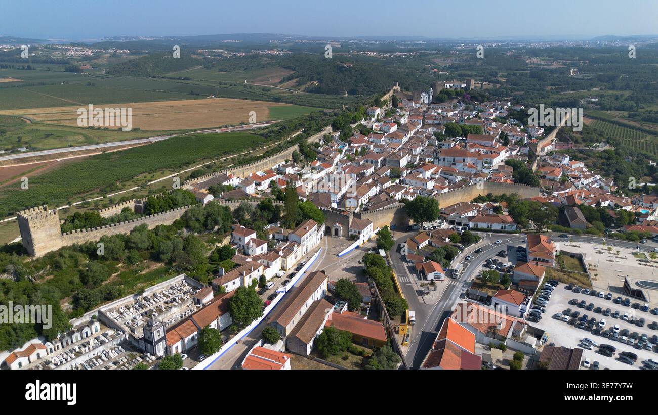 Vidéo aérienne par drone d'Óbidos au Portugal, une magnifique ville historique fortifiée médiévale dotée de fortifications de château anciennes et frappantes Banque D'Images