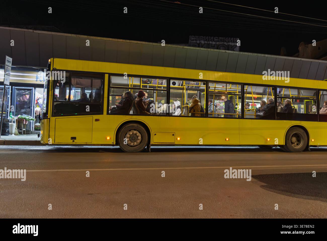 Jaune City bus avec des passagers la nuit près du marché Stryiskyi à Lviv Banque D'Images