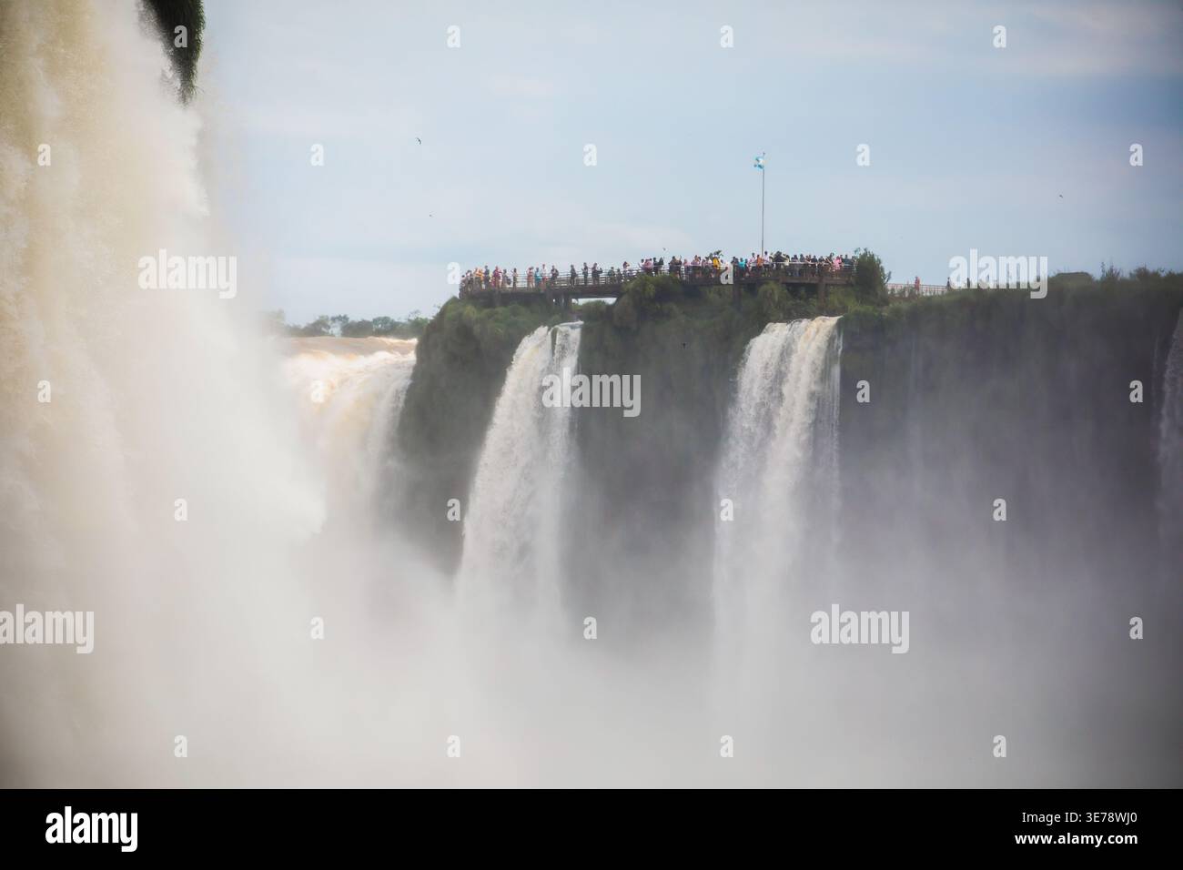 Point de vue des chutes du côté argentin. Des dizaines de touristes se sont rassemblés sur une plate-forme d'observation en bois perchée au bord des falaises surplombant le s. Banque D'Images