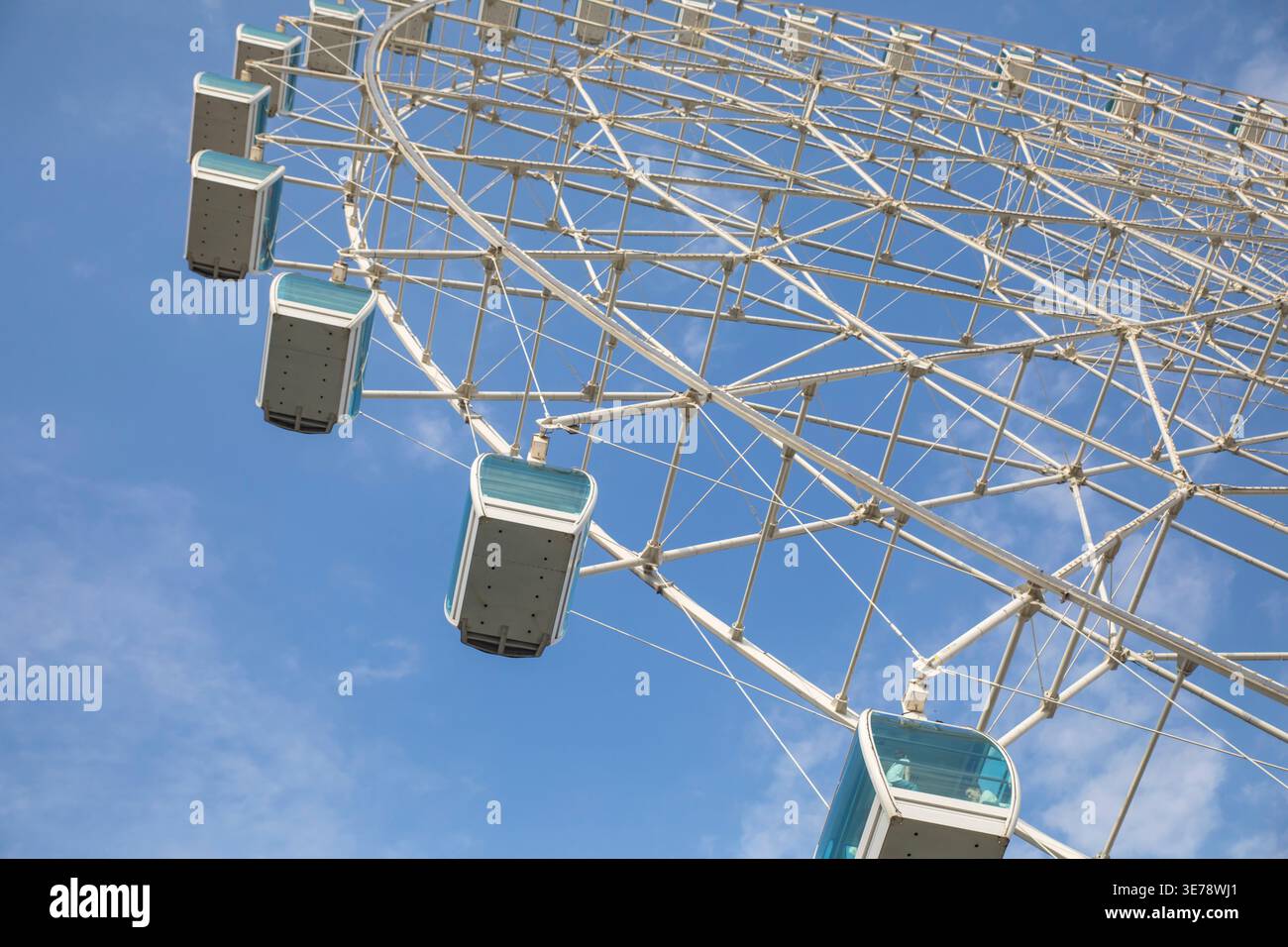 Une grande roue d'observation moderne domine le cadre, photographiée d'un angle bas regardant vers le haut sa structure en acier blanc et fermée PA Banque D'Images