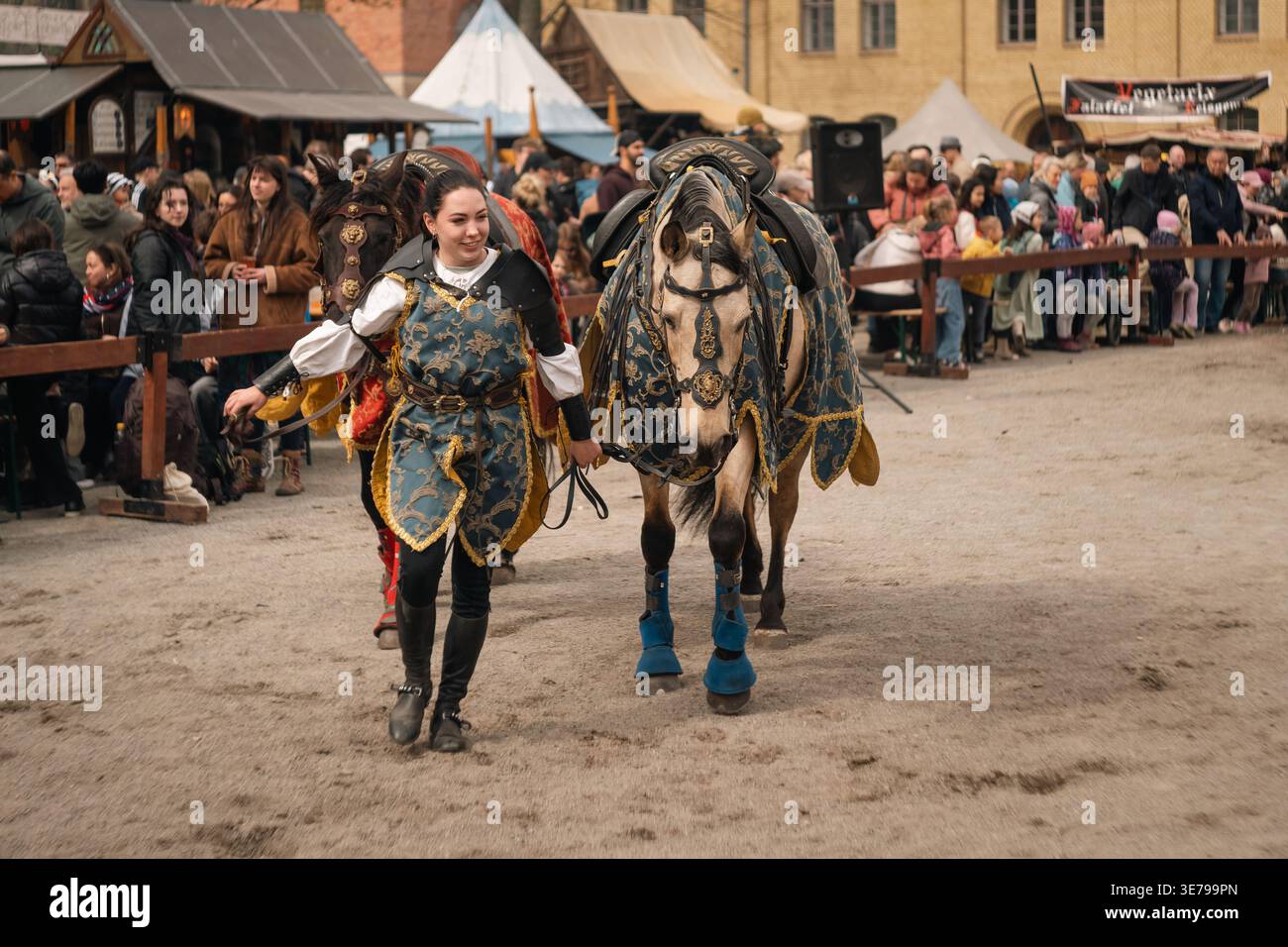 Berlin, Allemagne - 5 avril 2026 : une femme en costume d'inspiration médiévale conduit des chevaux décorés à travers l'arène lors d'un festival historique à Zitadel Banque D'Images