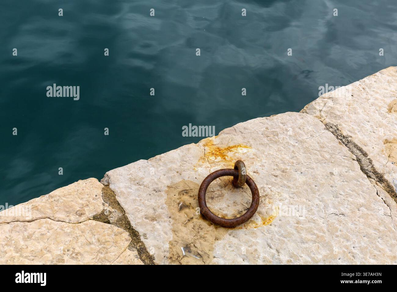 Ancien anneau en métal encastré dans la pierre près de la mer Adriatique. Détails côtiers minimes. Banque D'Images