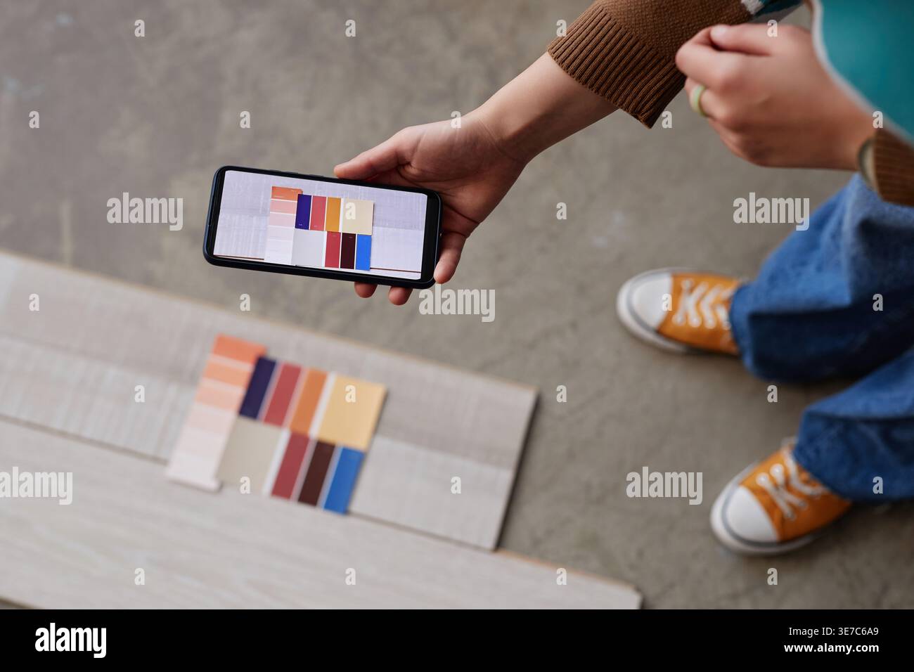 Mains de concepteur féminin mixte-race prenant en photo la palette de couleurs tout en se tenant debout dans le bureau Banque D'Images