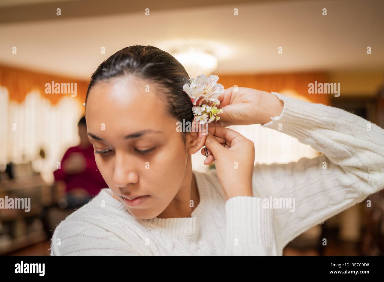 Gros plan d'une femme péruvienne se préparant à mettre des fleurs derrière son oreille à la maison Banque D'Images