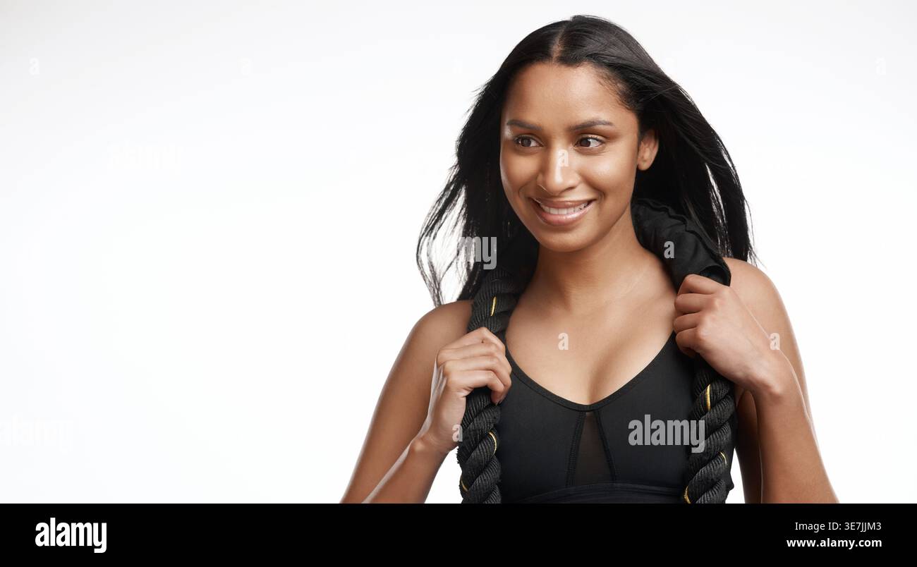 Pensée, fitness et femme avec corde de combat en studio pour la musculation, le bien-être et le cardio. Sourire, athlète et personne avec l'équipement pour Banque D'Images