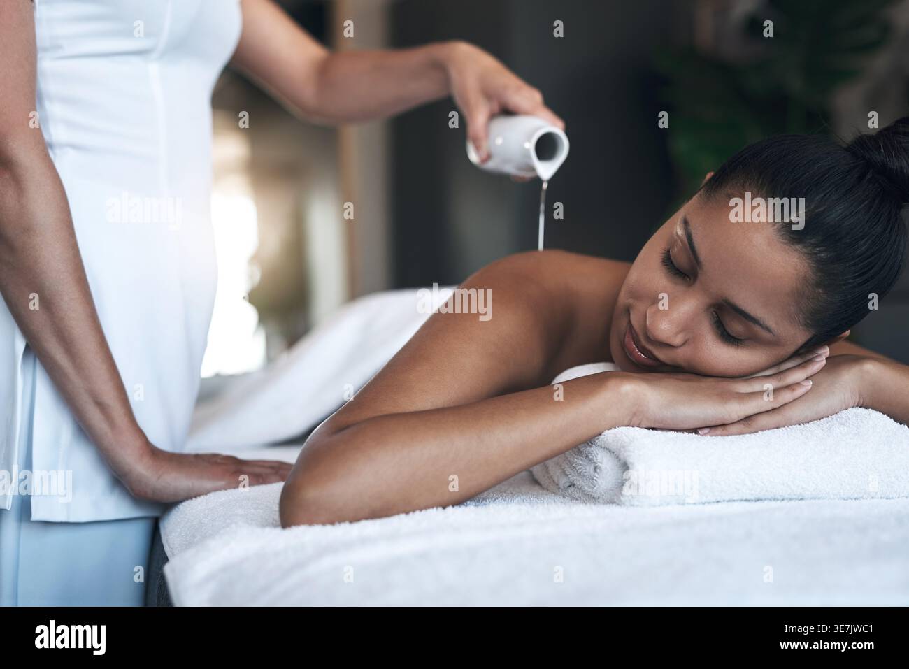 Thérapeute, calme et femme avec de l'huile pour le massage, le traitement des tissus profonds et la thérapie de relaxation musculaire. Bouteille, soulagement du stress ou masseuse avec client dans Banque D'Images