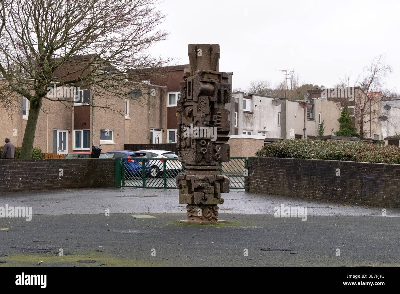 Sculpture de mât totémique en béton dans le parc pour enfants, Pitteuchar, Glenrothes, Fife, Écosse. Art public dans un cadre résidentiel New Town, un jour de pluie. Banque D'Images