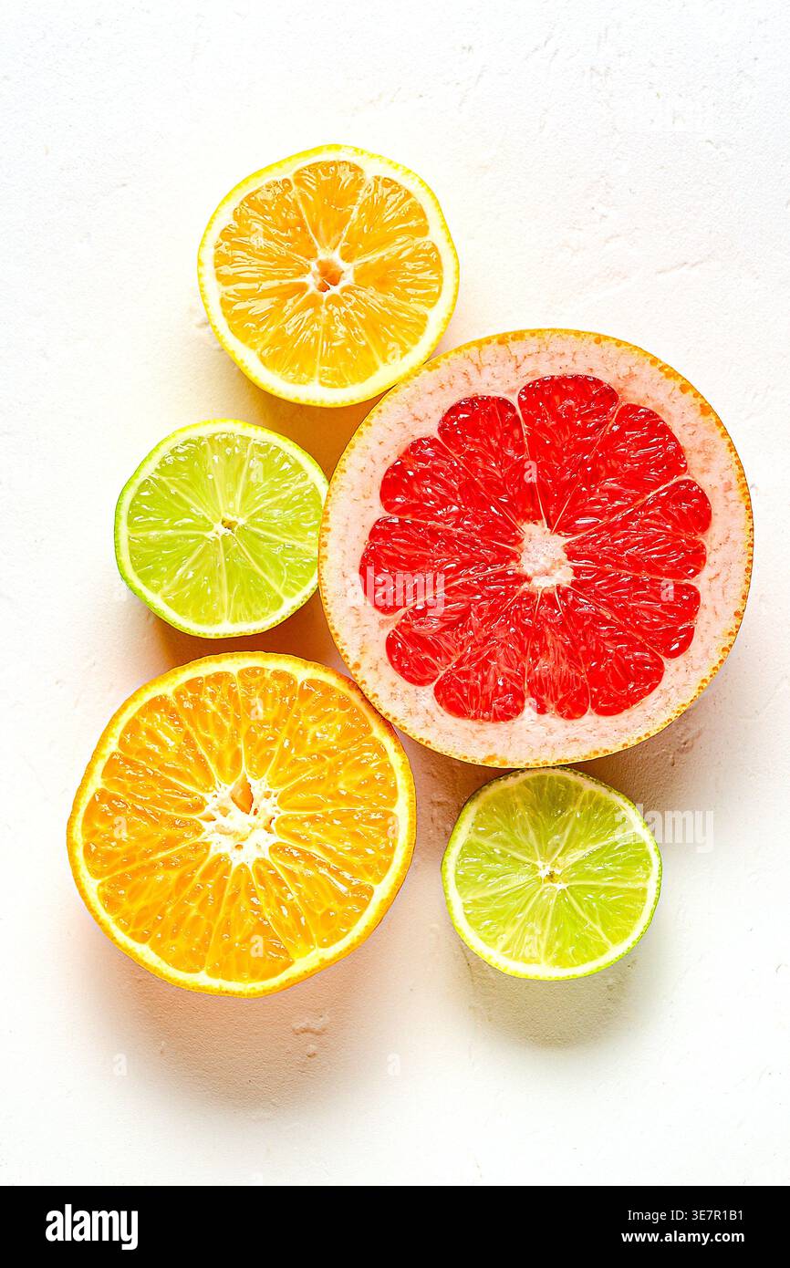 Citron frais, orange, pamplemousse, citron vert sur fond clair, vue de dessus. Concept de jus d'agrumes, vitamine C, fruits. Banque D'Images