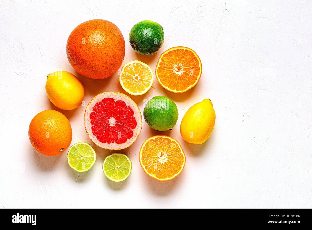 Citron frais, orange, pamplemousse, citron vert sur fond clair, vue de dessus. Concept de jus d'agrumes, vitamine C, fruits. Banque D'Images
