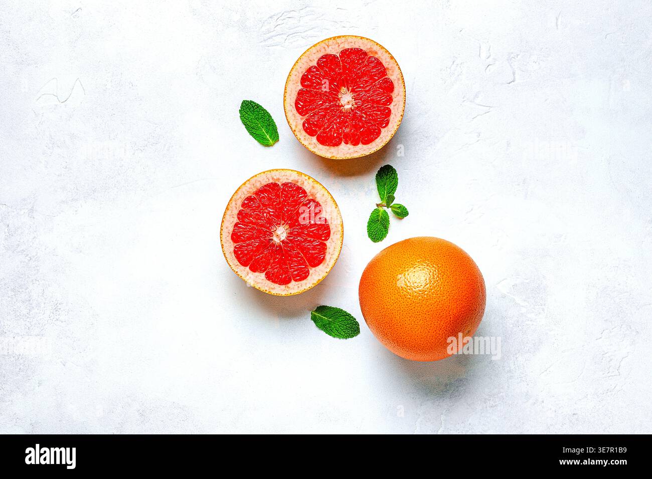 Orange frais, pamplemousse, feuilles vertes sur fond clair, vue de dessus. Concept de jus d'agrumes, vitamine C, fruits. Banque D'Images