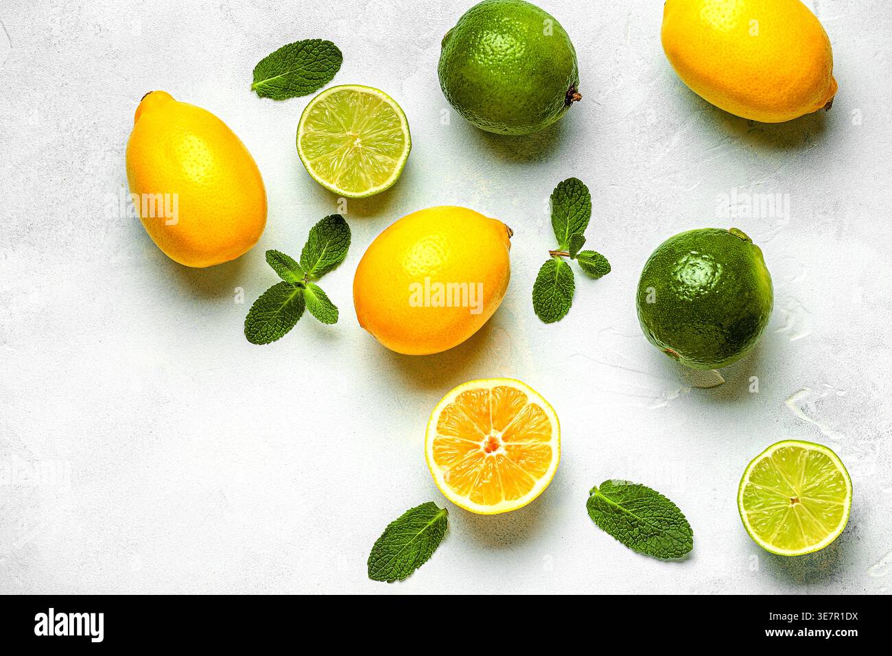 Citron frais, citron vert, feuilles vertes sur fond clair, vue de dessus. Concept de jus d'agrumes, vitamine C, fruits. Banque D'Images
