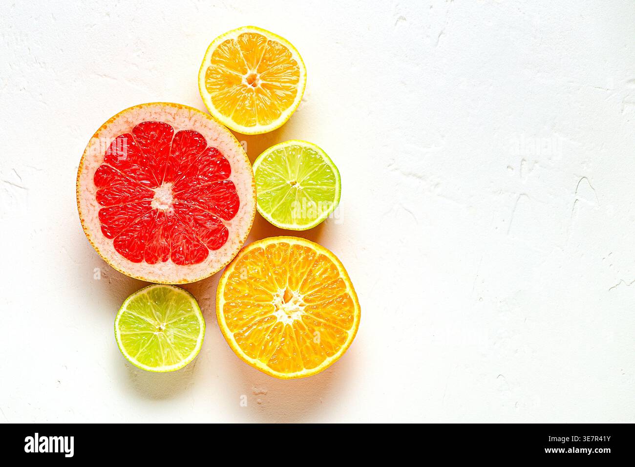 Citron frais, orange, pamplemousse, citron vert sur fond clair, vue de dessus. Concept de jus d'agrumes, vitamine C, fruits. Banque D'Images